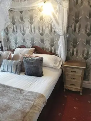 a bedroom with a bed with a canopy and a table at The Trafalgar in Blackpool