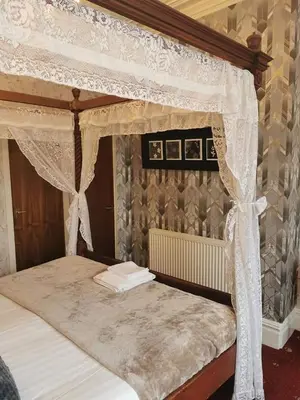 a bedroom with a canopy bed with white curtains at The Trafalgar in Blackpool