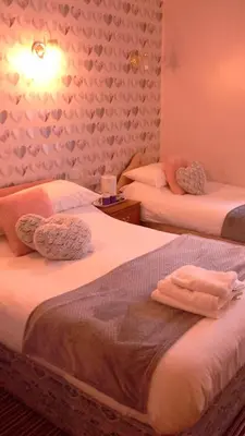 a bedroom with two beds with towels on them at The Trafalgar in Blackpool
