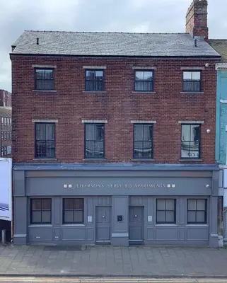 a brick building with a sign on the front of it at Jeffersons Hotel & Serviced Apartments in Barrow in Furness