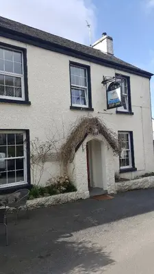a white brick building with a door and an entrance at The Ship Inn in Bardsea