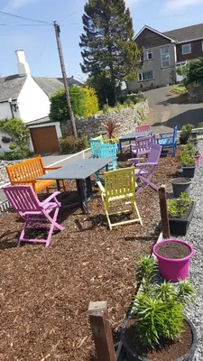 a group of colorful chairs and a table in a yard at The Ship Inn in Bardsea