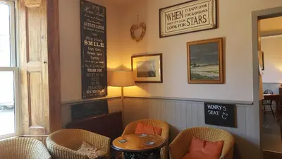a restaurant with chairs and a table and a chalkboard at The Ship Inn in Bardsea