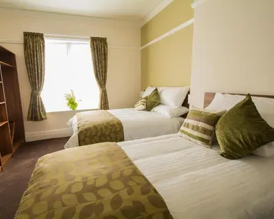 a hotel room with two beds and a window at Bloomfield Brewhouse in Blackpool
