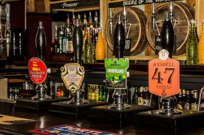 a bar with a bunch of signs on the counter at Bloomfield Brewhouse in Blackpool