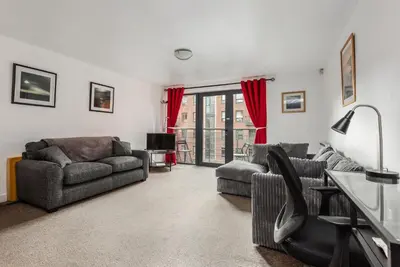 a living room with two couches and a table at Liverpool City Centre Apartments - East Village in Liverpool