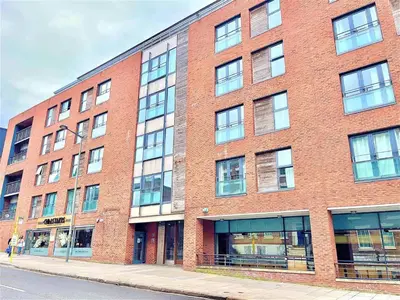 a large brick building with windows on a street at Liverpool City Centre Apartments - East Village in Liverpool