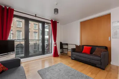 a living room with a couch and a tv at Liverpool City Centre Apartments - East Village in Liverpool