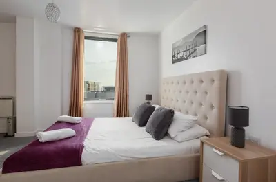 a bedroom with a large bed with a window at Liverpool City Centre Apartments - East Village in Liverpool