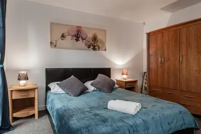 a bedroom with a blue bed with two night stands at Liverpool City Centre Apartments - East Village in Liverpool