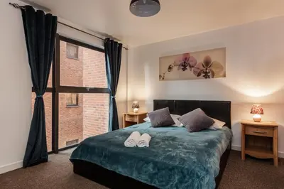 a bedroom with a bed with two shoes on it at Liverpool City Centre Apartments - East Village in Liverpool