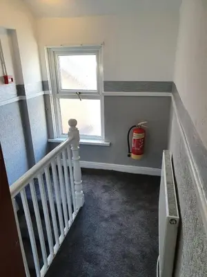 a stairway with a window and a white stair case at The Lodge Guest Accommodation in Barrow in Furness