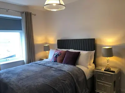a bedroom with a bed with two lamps and a window at Ten Streets Bed & Breakfast in Liverpool