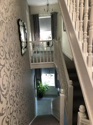 a hallway with a staircase with a window and a plant at Ten Streets Bed & Breakfast in Liverpool