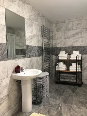 a bathroom with a sink and a mirror and towels at Ten Streets Bed & Breakfast in Liverpool