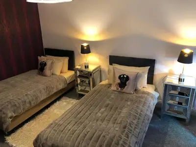 a bedroom with two beds and two tables with lamps at Ten Streets Bed & Breakfast in Liverpool