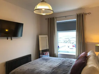 a bedroom with a bed and a large window at Ten Streets Bed & Breakfast in Liverpool