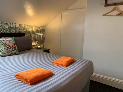 two orange pillows on a bed in a room at Tropics Beach Hotel in Blackpool
