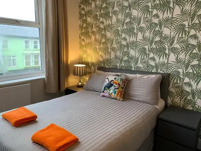 a bedroom with a bed with orange towels on it at Tropics Beach Hotel in Blackpool
