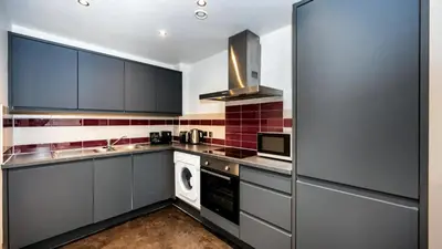 a kitchen with gray cabinets and a stove top oven at Staycity Aparthotels Liverpool City Centre in Liverpool