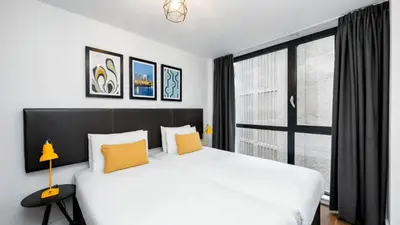 a bedroom with a white bed and a large window at Staycity Aparthotels Liverpool City Centre in Liverpool