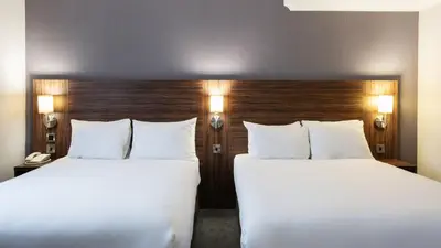 two beds in a hotel room with white pillows at Holiday Inn Liverpool City Centre by IHG in Liverpool