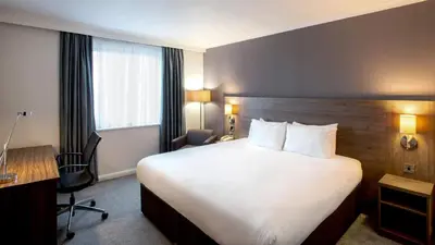 a hotel room with a large bed and a desk at Holiday Inn Liverpool City Centre by IHG in Liverpool