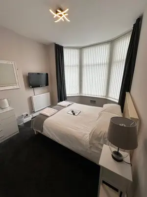 a bedroom with a large bed and a tv at The Villa Hotel in Blackpool