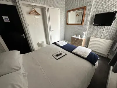 a bedroom with a bed with a mirror and a television at The Villa Hotel in Blackpool