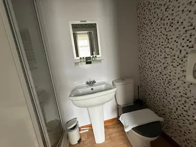 a bathroom with a sink and a toilet and a mirror at The Villa Hotel in Blackpool
