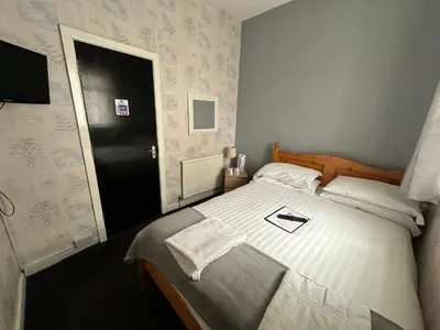 a bedroom with a bed and a black door at The Villa Hotel in Blackpool
