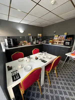 a dining room with a table and red chairs at The Villa Hotel in Blackpool