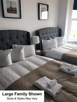 a bedroom with two beds and a large family show at Seafront419 By Seafront Collection in Blackpool