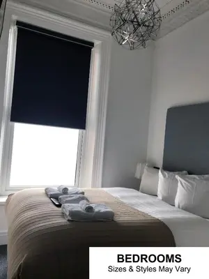 a bedroom with a bed with a window and a chandelier at Seafront419 By Seafront Collection in Blackpool
