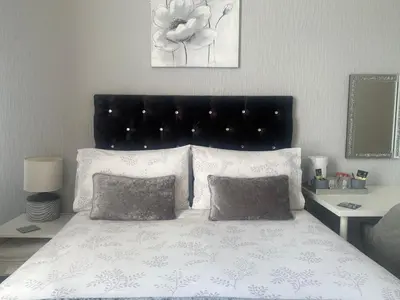 a bedroom with a bed with a black headboard and pillows at Brene Hotel in Blackpool