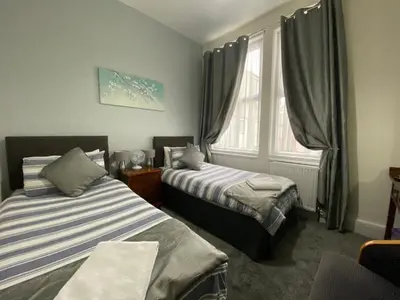 a room with two beds and a window at Brene Hotel in Blackpool