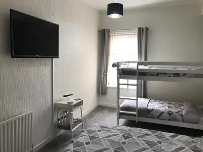 a bedroom with two bunk beds and a flat screen tv at Brene Hotel in Blackpool