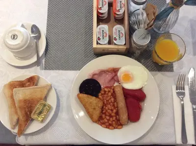 a plate of food with eggs and beans on a table at Brene Hotel in Blackpool