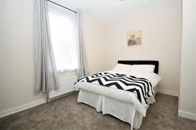 a bedroom with a black and white bed and a window at Maritime Apartments in Barrow in Furness