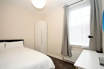 a bedroom with a white bed and a window at Maritime Apartments in Barrow in Furness