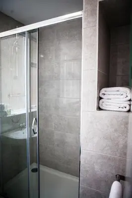 a shower with a glass door and a sink at Maritime Apartments in Barrow in Furness