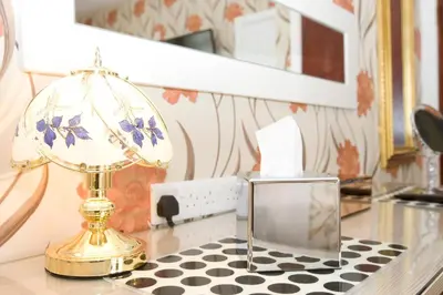 a lamp on a table with a clock on it at Valentine Lodge Over 21 Adult Couples Only in Blackpool