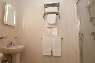 a bathroom with a sink and a shower and towels at Valentine Lodge Over 21 Adult Couples Only in Blackpool