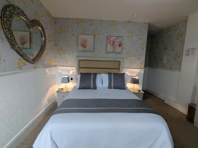 a bedroom with a large bed and a mirror at Valentine Lodge Over 21 Adult Couples Only in Blackpool