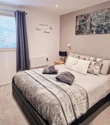 a bedroom with a bed with two pillows on it at Fenna Lakeside Lodge - Pine Lake Resort in Carnforth