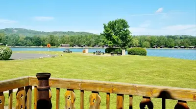 a wooden fence with a view of a lake at Fenna Lakeside Lodge - Pine Lake Resort in Carnforth