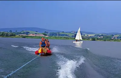 a couple of people are riding on a boat in the water at Fenna Lakeside Lodge - Pine Lake Resort in Carnforth