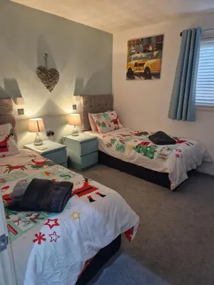 a bedroom with two beds and two nightstands and two beds sidx sidx sidx at Fenna Lakeside Lodge - Pine Lake Resort in Carnforth