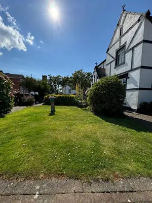 a house with a grassy yard next to a building at The Old Coach House in Blackpool