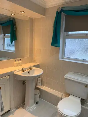 a bathroom with a sink and a toilet and a window at The Old Coach House in Blackpool